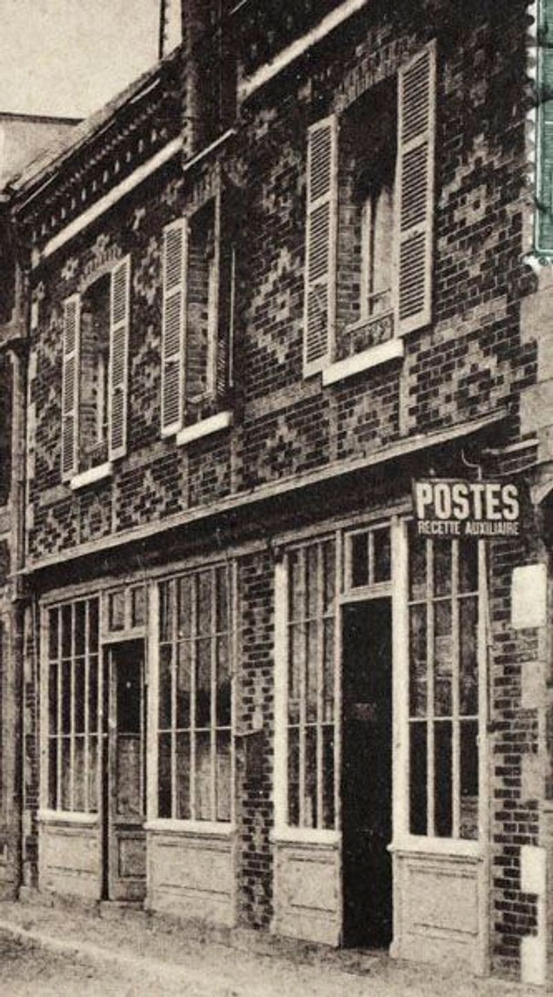 Photographie ancienne d’une devanture de brique portant l’enseigne « Postes — Recette auxiliaire »